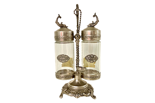 1 SET DA TAVOLO “FABBRI” SUPPORTO CON MANICO, 2 BOTTIGLIE IN CRISTALLO PER AMARENE E CUCCHIAIO, METALLO COLORE ARGENTO DIM. 19x35x16 CM